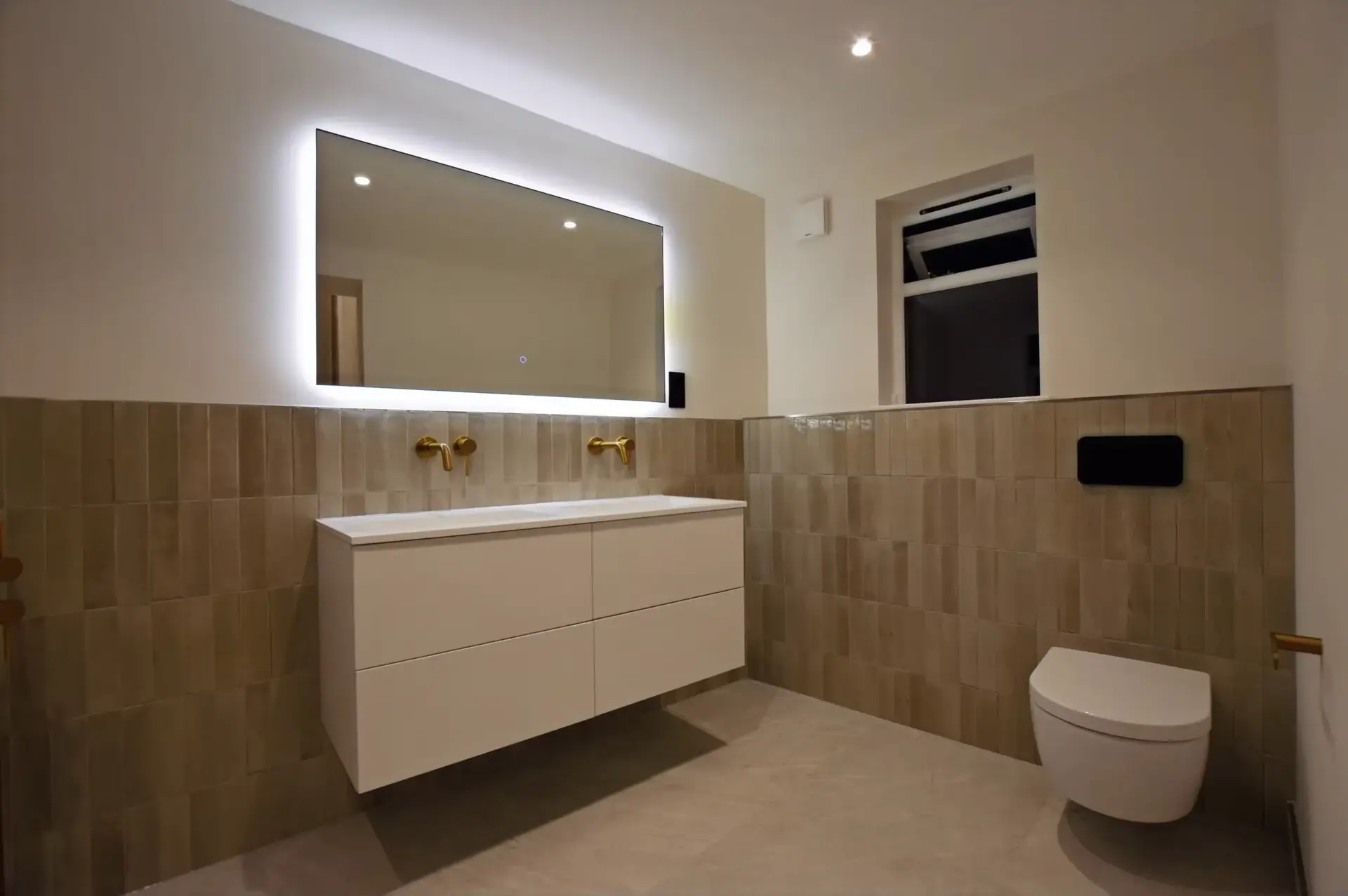 Double vanity with brushed brass taps and backlit mirror, family bathroom, Clapham