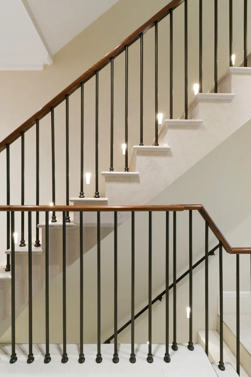 Marble staircase with iron balustrade, wood handrail and LED step lighting, London