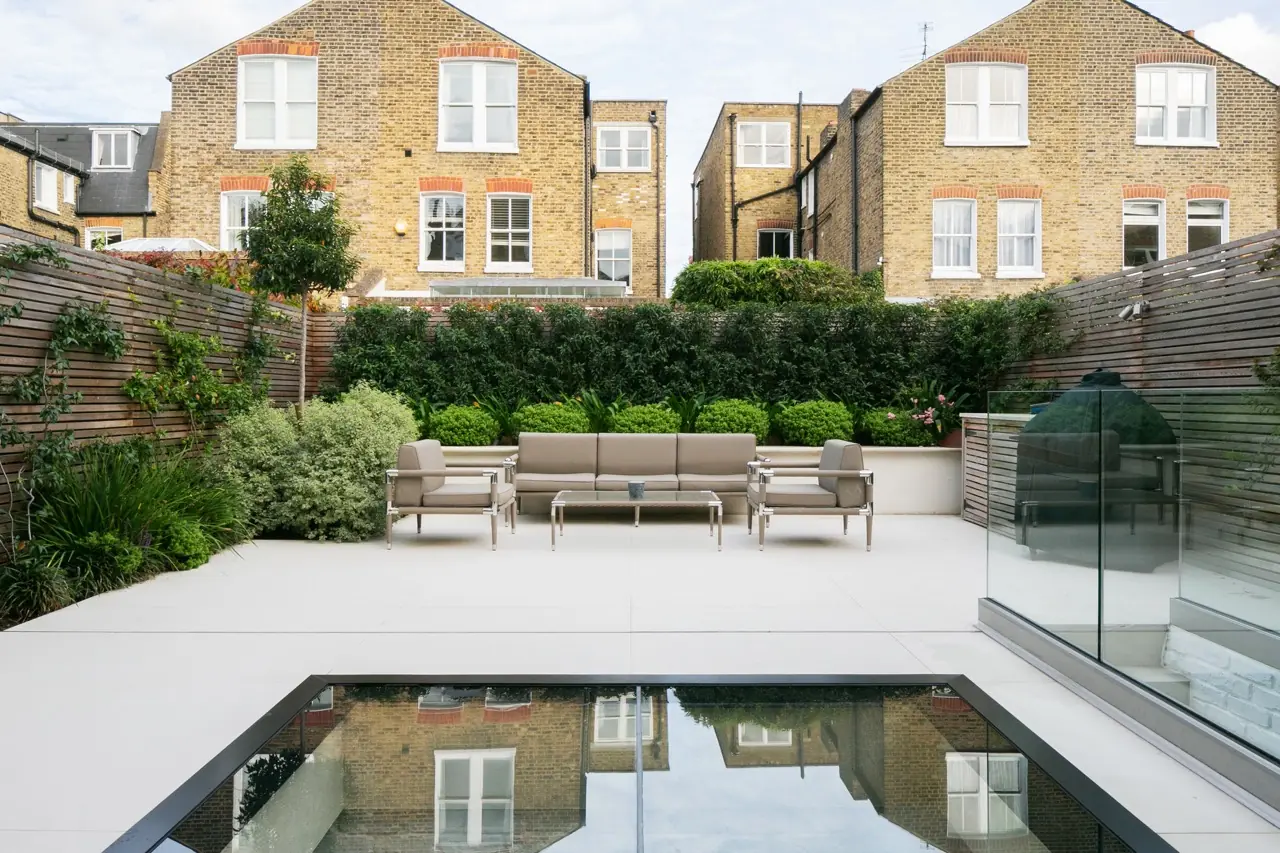 Rear garden terrace with glass rooflight and outdoor seating, London house extension