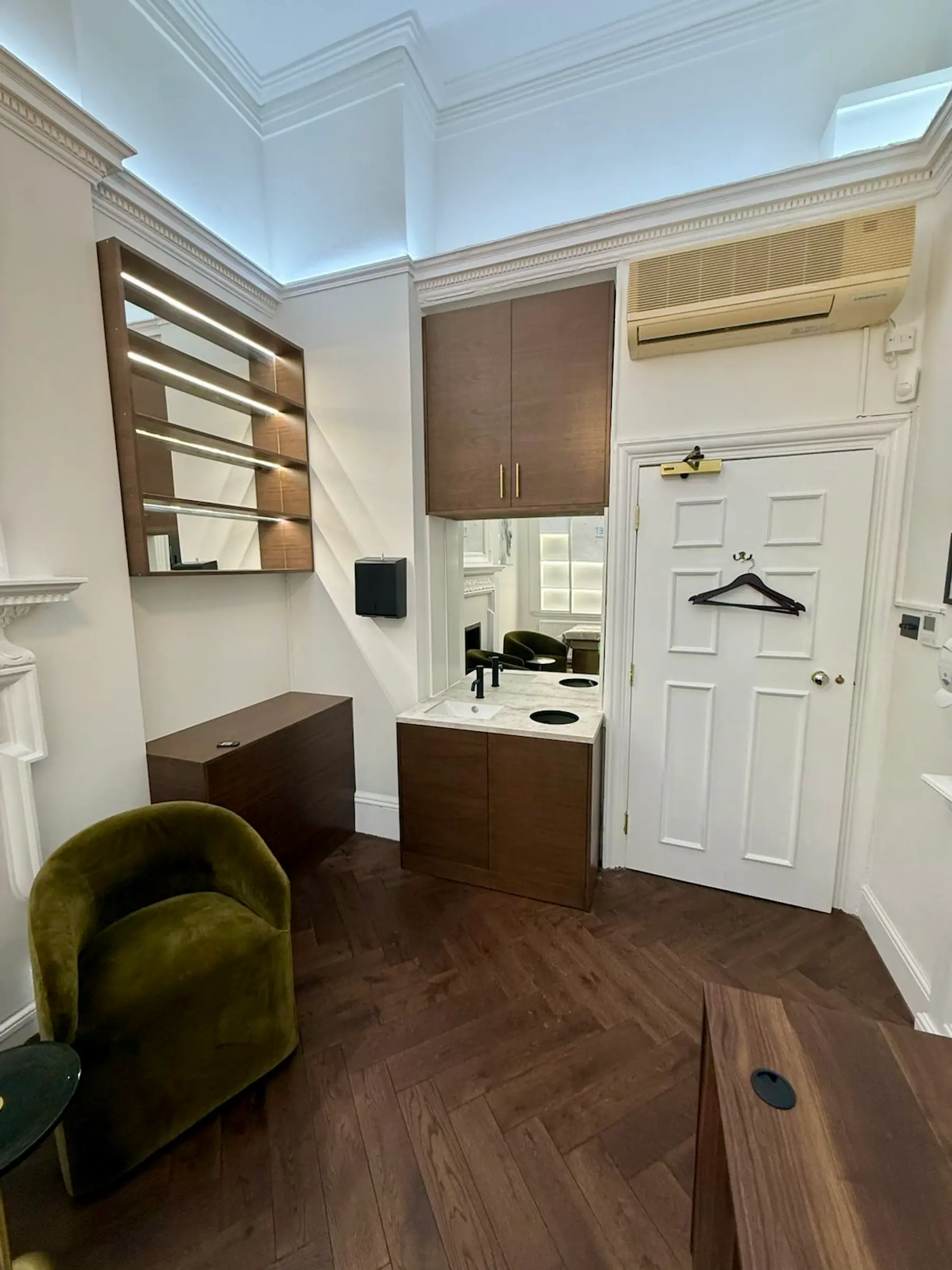 Completed consulting room - herringbone oak flooring, split-zone LED lighting with cornice perimeter strip and pendant lantern - Harley Street W1G