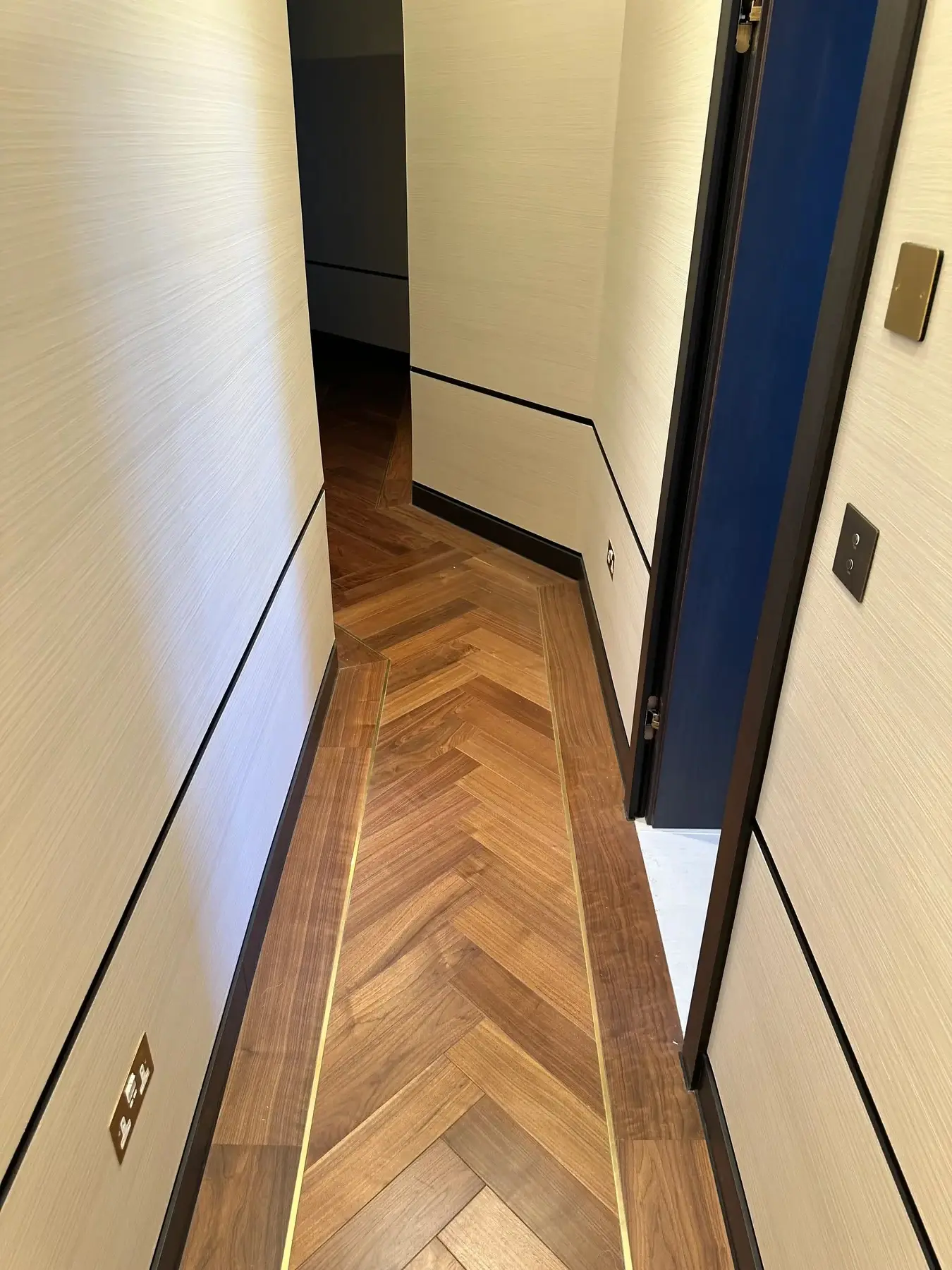 Hallway with walnut herringbone flooring and brass inlay - Holland Park London apartment