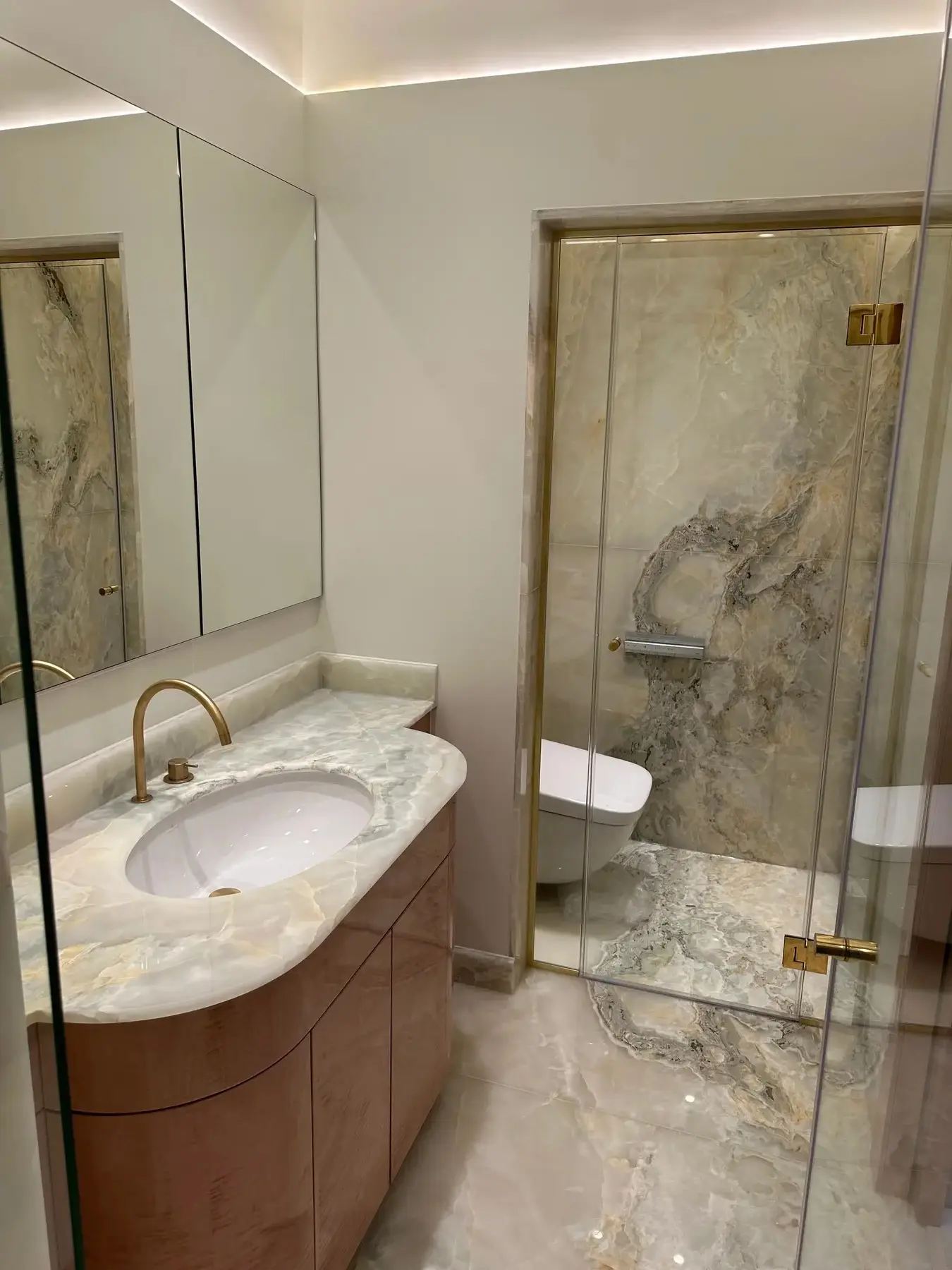 Apartment bathroom with onyx basin, gold tap and shower enclosure - Holland Park London