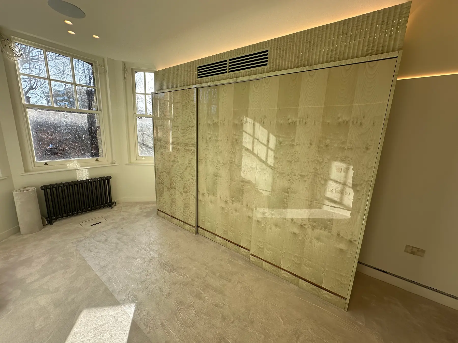 Bedroom with burl wood high-gloss sliding wardrobes and LED ceiling - London apartment refurbishment
