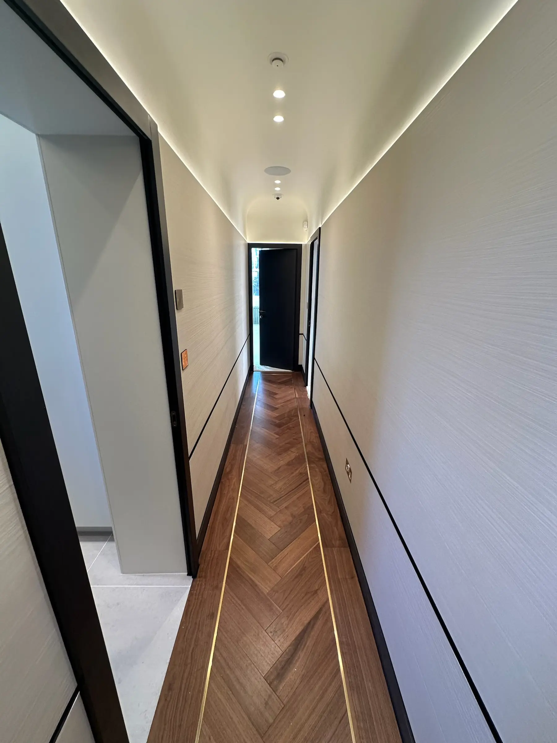 Corridor with herringbone walnut flooring, brass inlay and LED ceiling - Holland Park apartment refurbishment