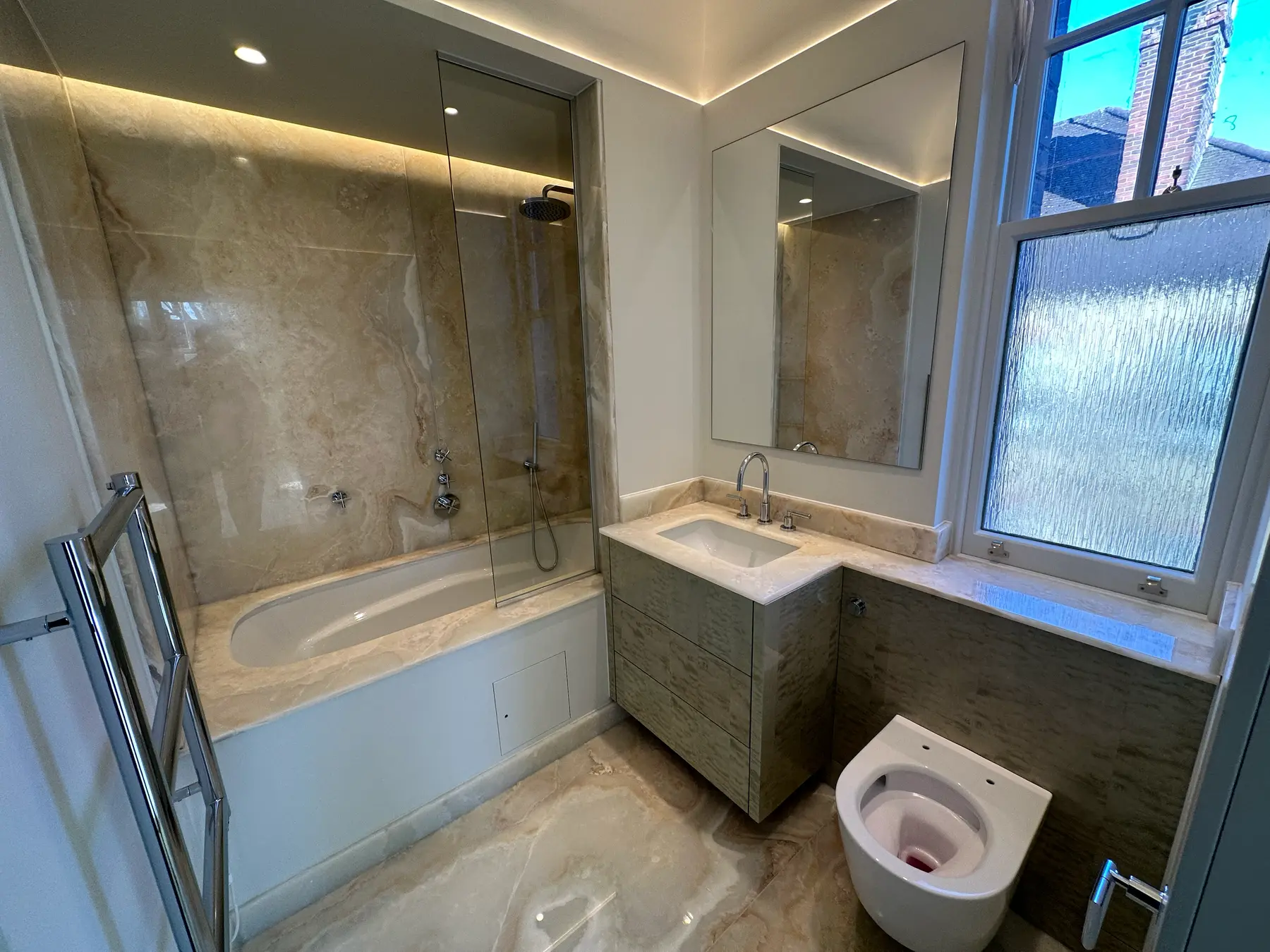 Ensuite with travertine marble bath surround, vanity and LED ceiling - Holland Park apartment refurbishment