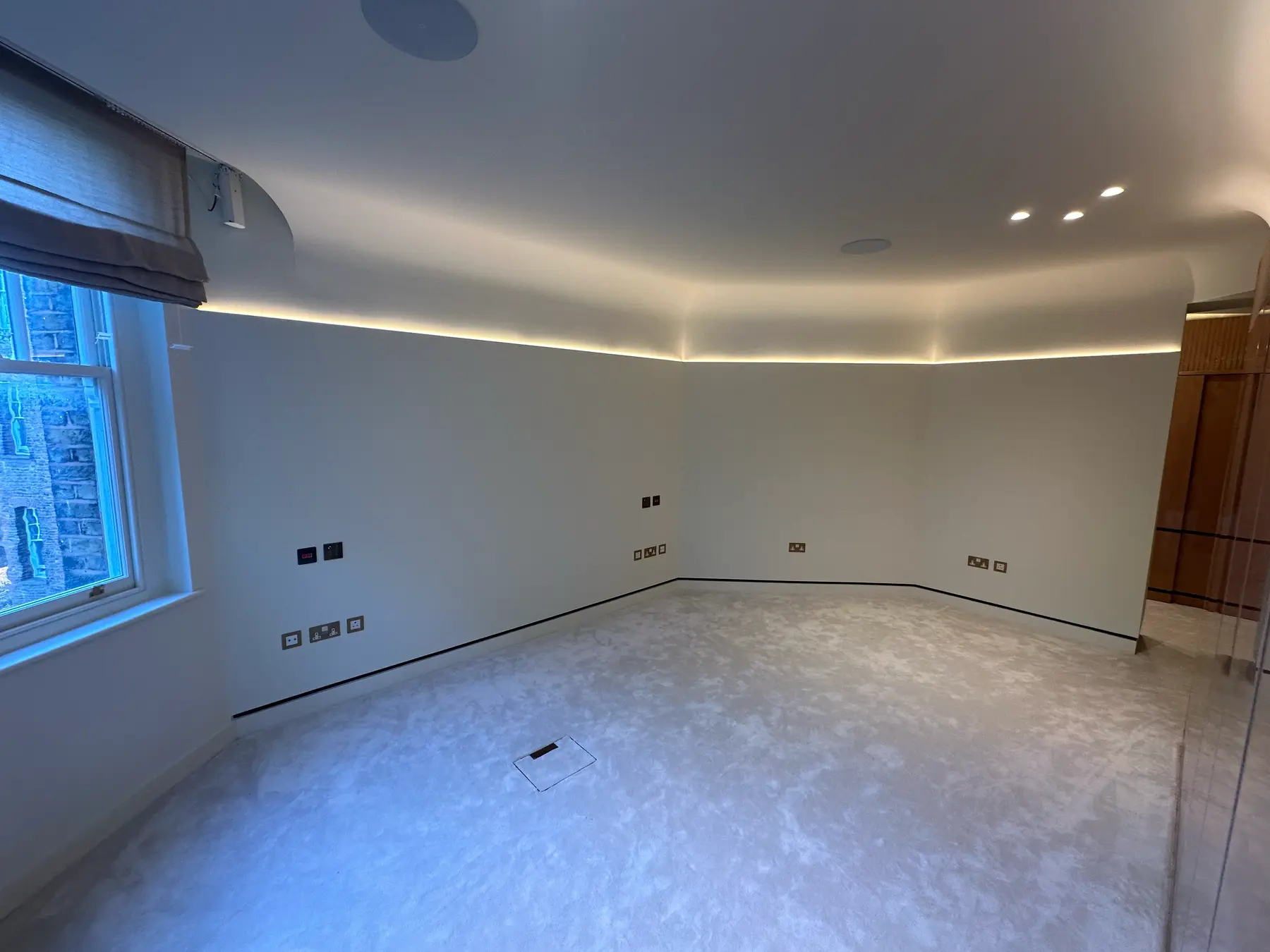Master bedroom with curved walls, LED strip ceiling, carpet and burl wood wardrobes - Holland Park London