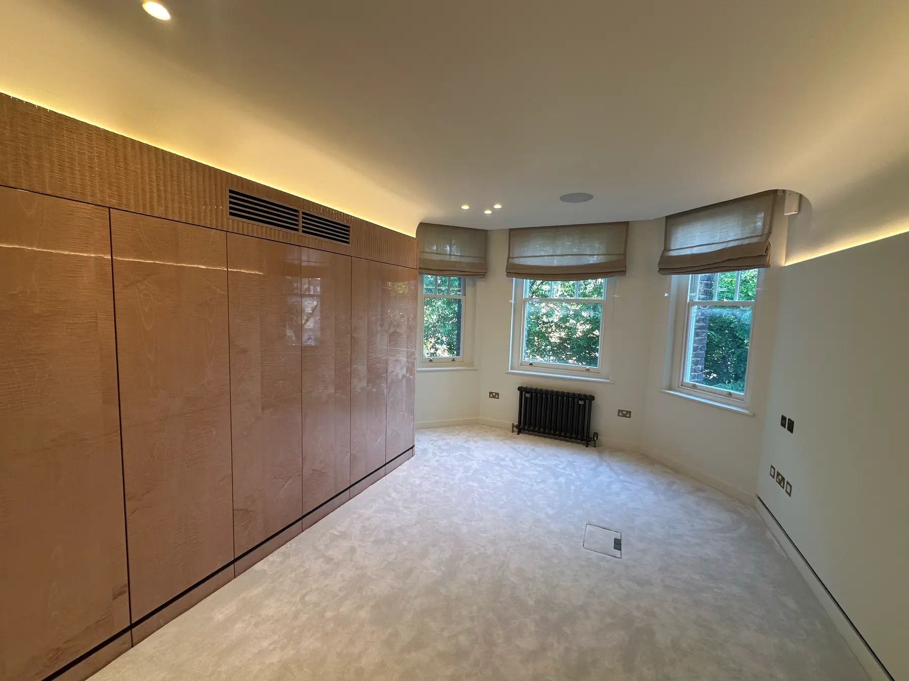 Master bedroom with high-gloss burl wood wardrobes, bay windows, carpet and LED ceiling - Holland Park