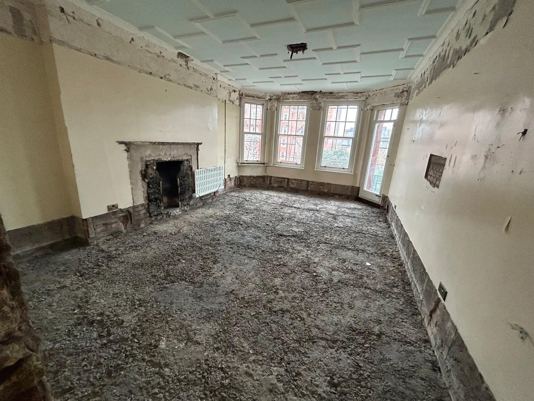 Reception room before refurbishment - stripped back to shell with rubble floor - Holland Park London