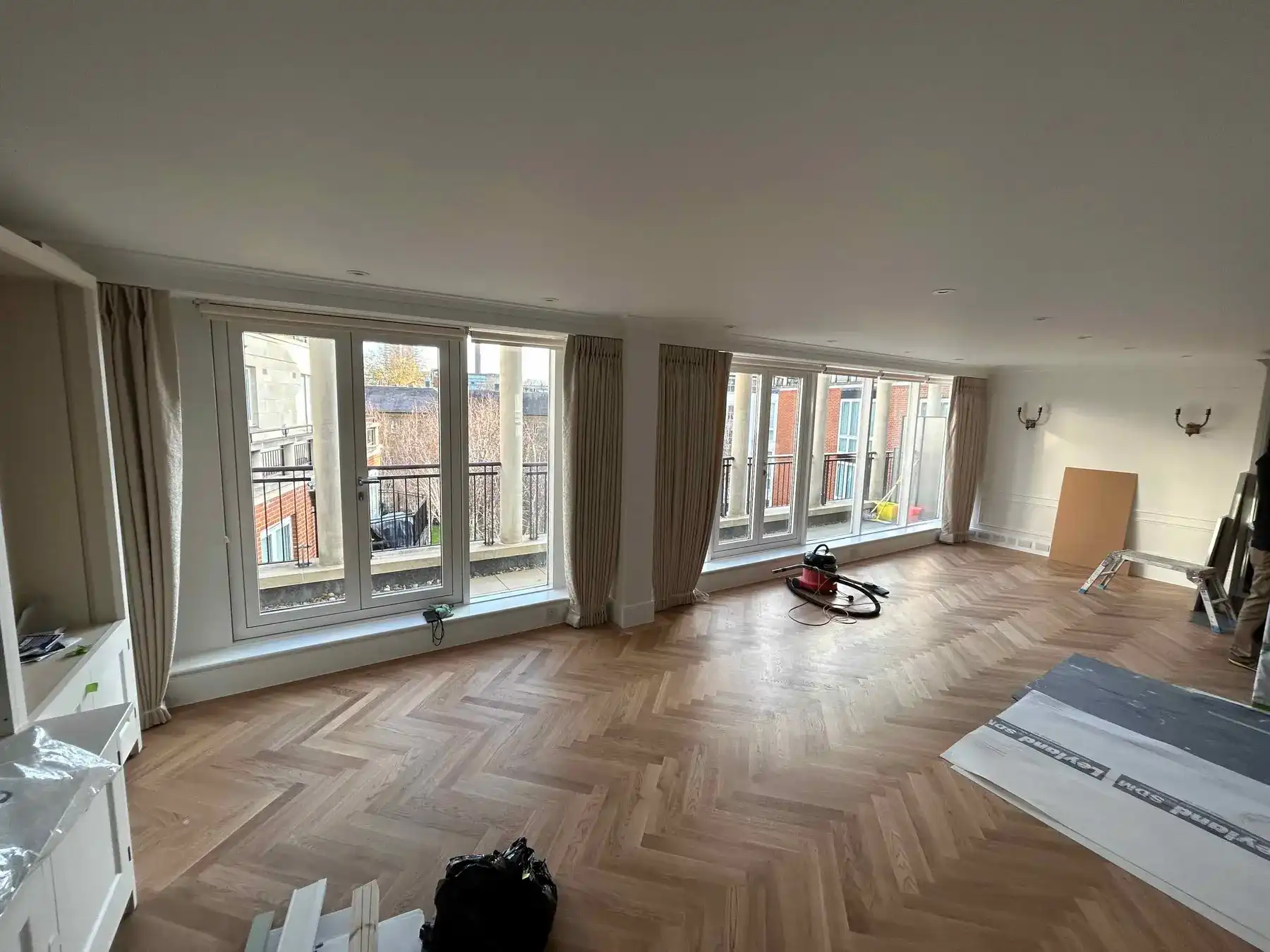 Apartment lounge with herringbone oak flooring and floor-to-ceiling windows - Kings Road Chelsea