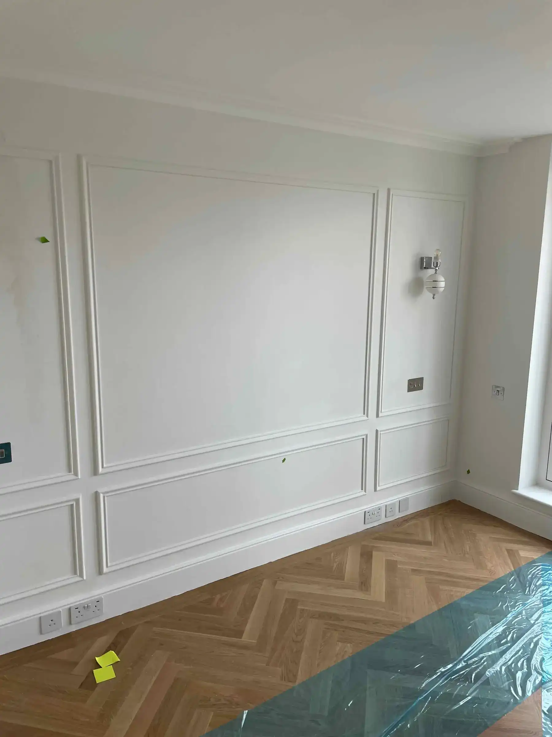 Bedroom with wall panelling, mouldings and herringbone flooring - London apartment Kings Road