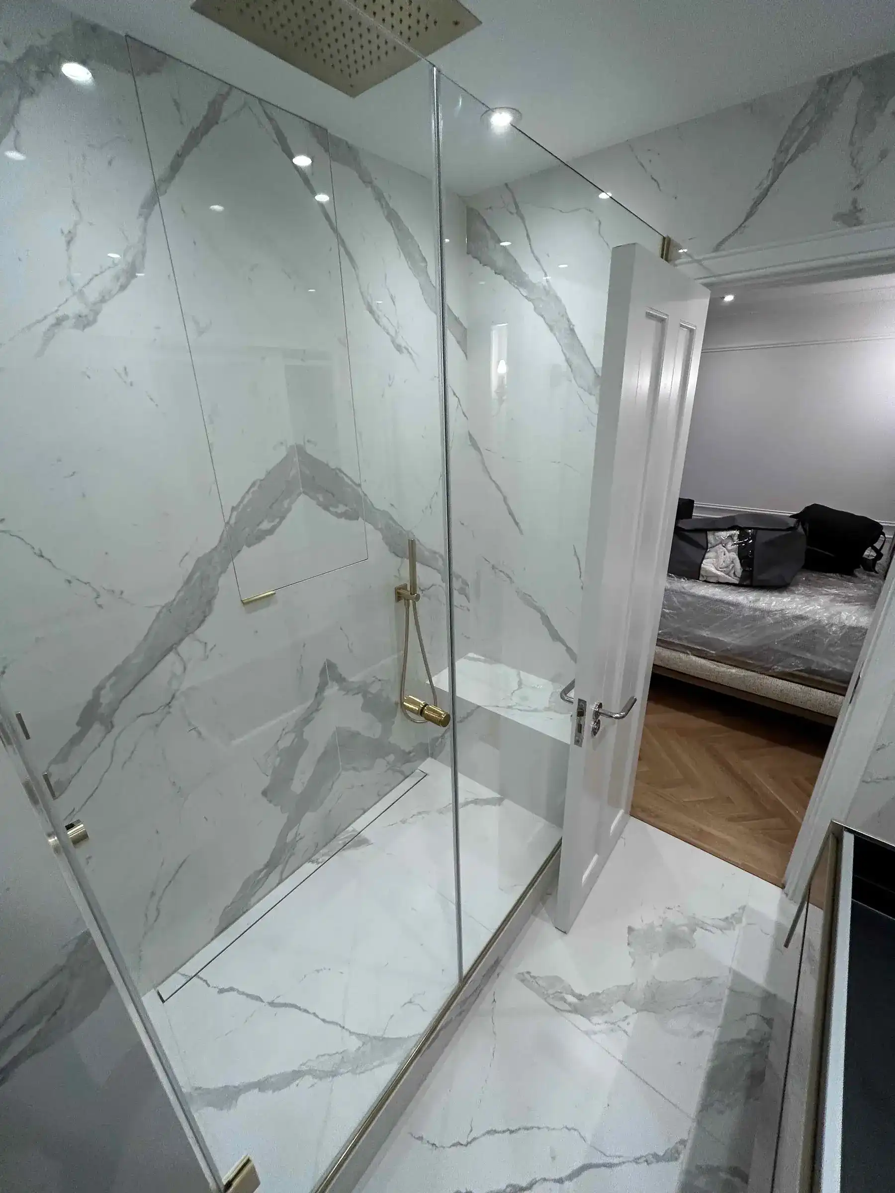 Ensuite shower with marble tiling and gold fittings - Chelsea London apartment